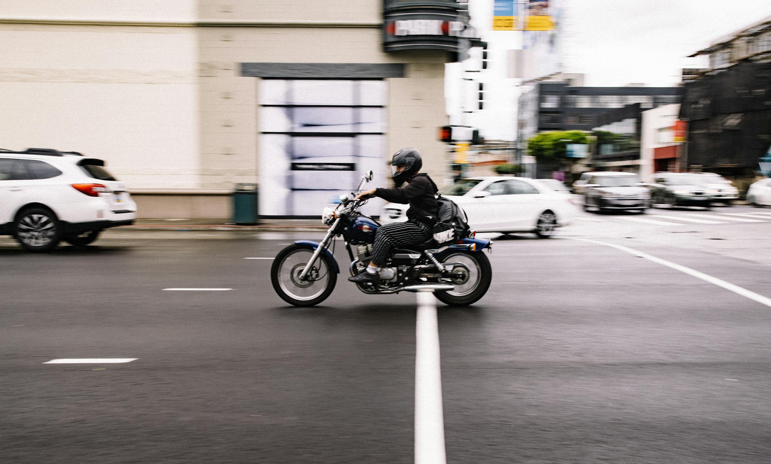 Motorcyclist speeds through a busy city street in San Francisco, California.